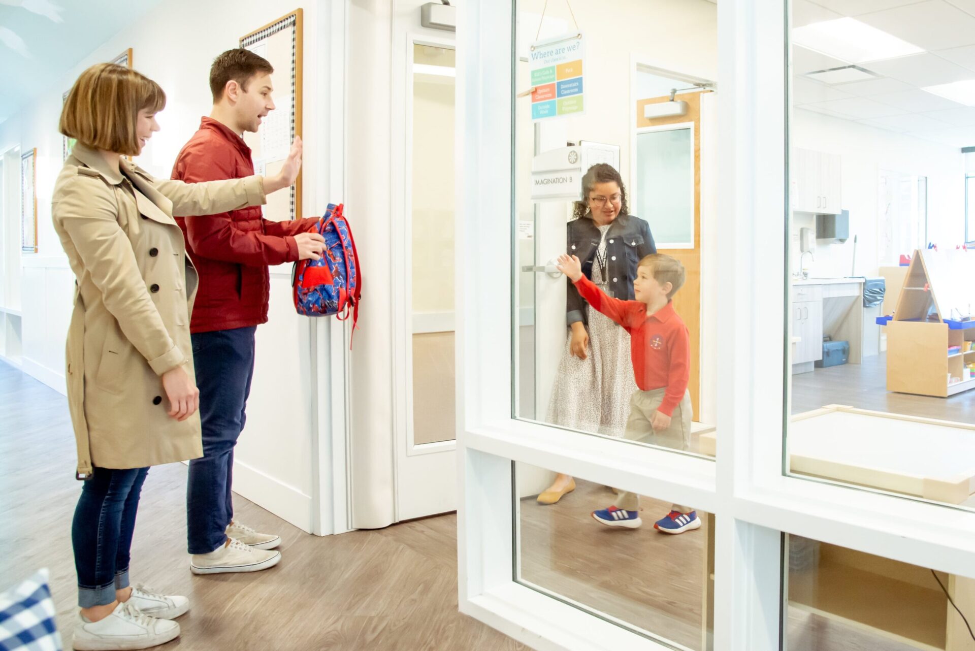 parents waving goodbye to their son at preschool daycare