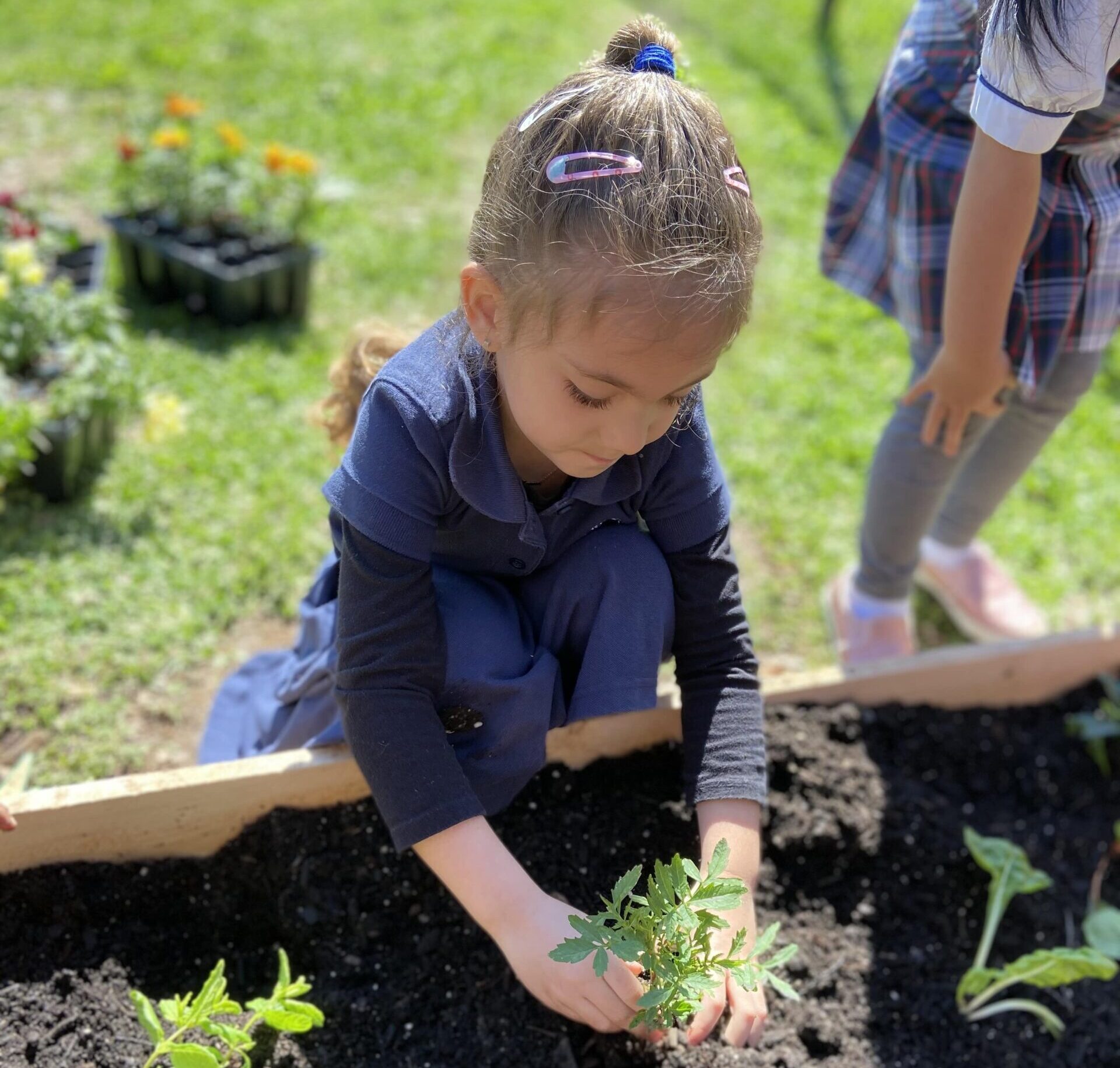 preschooler planting in a garden on Earth Day