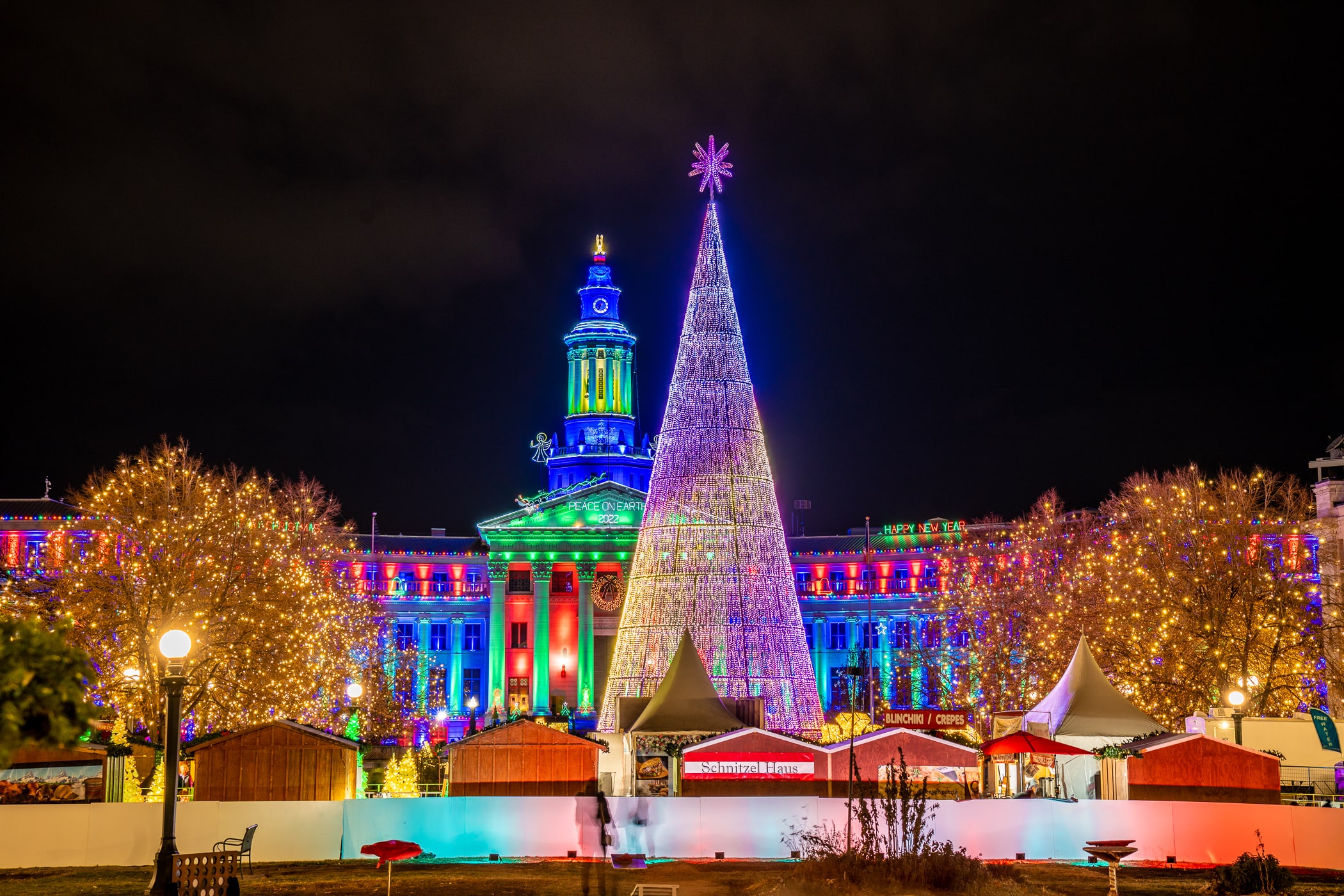 Mile High Tree lit up at night in Denver