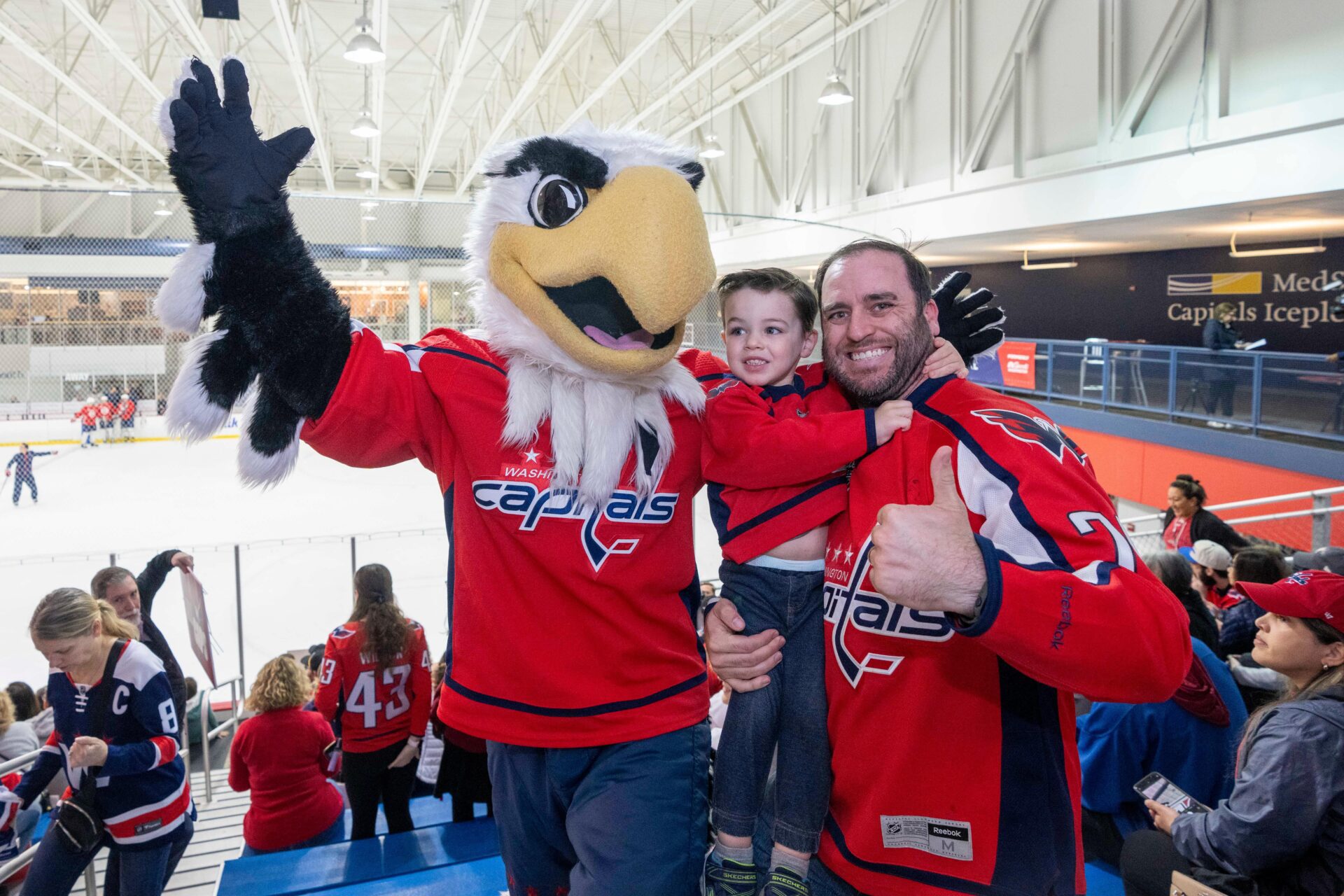 father and son with mascot at Washington Capitals hockey game
