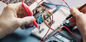 student working on wires on an electronic device