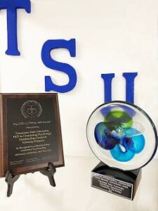 the text TSU in a blue color and a frame with an award