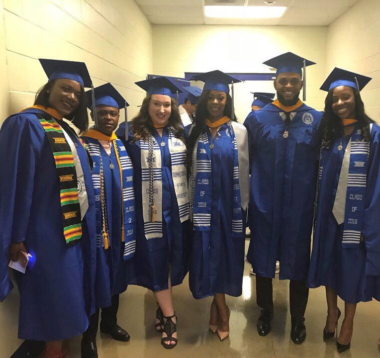a group of students standing together wearing caps and gowns