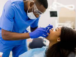 a dentist checking inside a patient's mouth