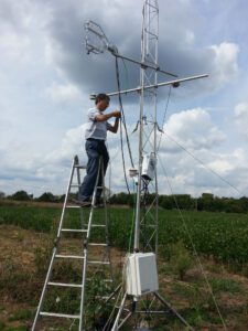 Dr. Dafeng Hui working on an attenna in a field.