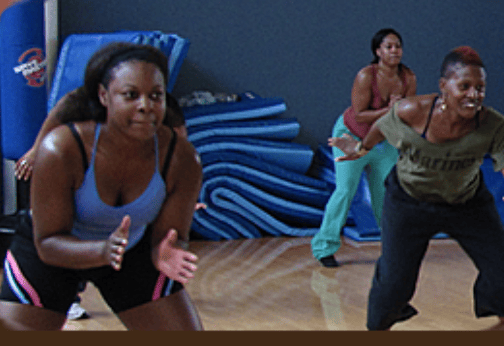 three students with their knees bent doing an exercise